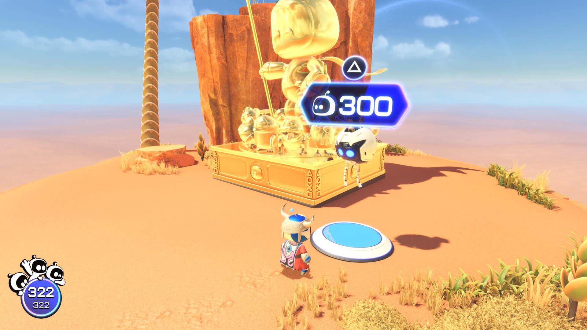 Astrobot stands in front of a giant button and a golden statue.